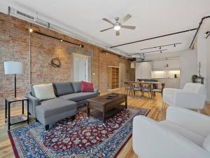 een woonkamer met een bank en een tafel bij Findlay Suites Explore OTR with an Outdoor Deck in Cincinnati