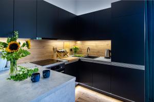 a kitchen with black cabinets and a vase of flowers on a counter at Złota Widokówka in Jaworze