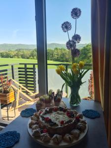 una mesa con un pastel y un jarrón de flores en Złota Widokówka, en Jaworze