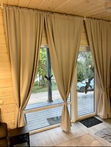 a large window with curtains in a room at Obuoliu Sala COZY HOUSE on the Apple Island in Gaylyunay