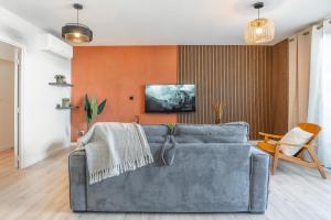 a living room with a couch and an orange wall at Exceptionnel ! Appart luxueux à 8 min à pied du lagon in La Saline les Bains