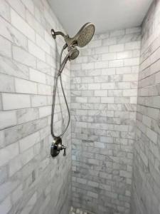 een douche met een douchekop op een bakstenen muur bij Cute Microapartment Walkable to Everything in Cincinnati