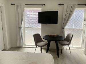 1 dormitorio con mesa, 2 sillas y TV en Cute Microapartment Walkable to Everything, en Cincinnati