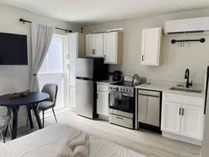 a kitchen with white cabinets and a table and a kitchen with a stove at Cute Microapartment Walkable to Everything in Cincinnati