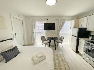ein Schlafzimmer mit einem weißen Bett und einem Tisch mit Stühlen in der Unterkunft Cute Microapartment Walkable to Everything in Cincinnati