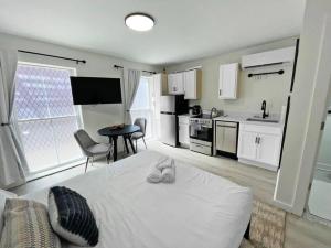 1 dormitorio con 1 cama blanca y cocina en Cute Microapartment Walkable to Everything, en Cincinnati