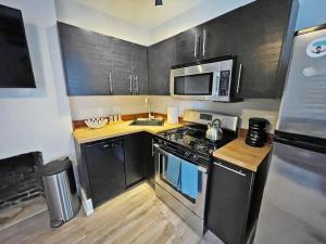 a small kitchen with a stove and a microwave at Quiet 1-Bedroom Loft near Entertainment District in Cincinnati +3 photos