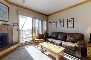 - un salon avec un canapé en cuir et une cheminée dans l'établissement Snow Flower 309, à Steamboat Springs