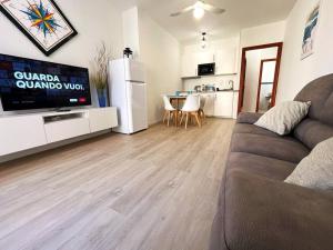 a living room with a couch and a tv and a kitchen at Apt. MarisDomus, 300m dal Centro in Pula