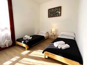 a room with two beds and a table and a window at Apt. MarisDomus, 300m dal Centro in Pula