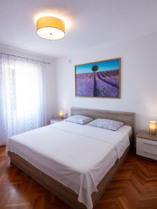 a bedroom with a large bed with white sheets at Apartments Kaja in Postira