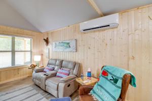 een woonkamer met een bank en een ventilator bij Beautiful Studio Cabin Near Greers Ferry Lake! in Fairfield Bay