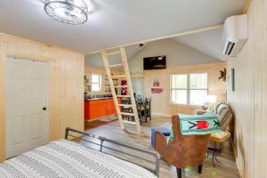 een slaapkamer met een bed en een keuken met een ladder bij Beautiful Studio Cabin Near Greers Ferry Lake! in Fairfield Bay