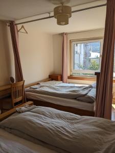 two beds in a room with a window at EDI b&b in Edinburgh