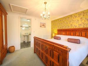 a bedroom with a wooden bed and a bathroom at Dune Cottage sleeps 2 with parking pet friendly close to St Ives & Penzance in Saint Erth