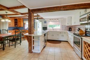 a large kitchen with white cabinets and a table at Cozy Vacation Rental Home Near Lake Winnipesaukee! in Wolfeboro