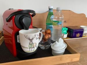 uma gaveta de madeira com comodidades para preparar café, uma chávena de café e uma caneca de café em Brookfield Cottage em West Kirby