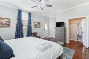 a bedroom with a white bed with a ceiling fan at Charming Apartment Retreat in Historic Jefferson! in Jefferson