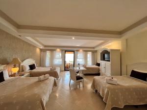 Habitación de hotel con 2 camas y sala de estar. en Excelaris Grand Resort Conventions & Spa en Tequesquitengo
