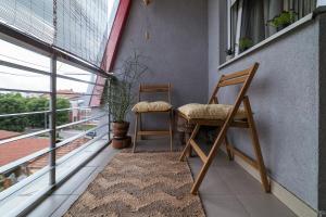 two chairs sitting on a balcony next to a window at Nana in Pirot