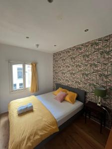 um quarto com uma cama com almofadas amarelas e rosas em Hostel Barbarossa em Nijmegen