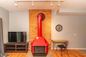 einen roten Kamin im Wohnzimmer mit einem TV in der Unterkunft Mt Adams 1BR Great Location Steps from Monastery in Cincinnati