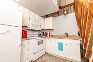 eine Küche mit weißen Schränken und einem weißen Kühlschrank in der Unterkunft Mt Adams 1BR Great Location Steps from Monastery in Cincinnati