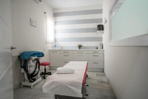 a hospital room with a bed and a chair at Hotel Balneario de Chiclana in Chiclana de la Frontera