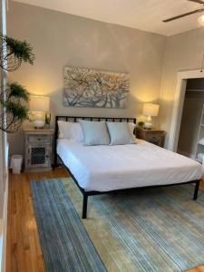 1 dormitorio con 1 cama blanca y 2 mesitas de noche en Lovely 2bd in Mount Adams near Downtown and OTR en Cincinnati