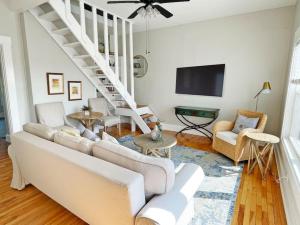 sala de estar con sofá blanco y escaleras en Lovely 2bd in Mount Adams near Downtown and OTR en Cincinnati