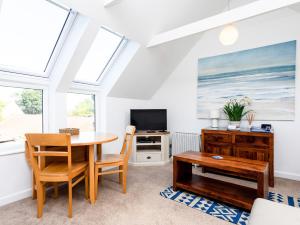 a living room with a table and chairs and a tv at Mistletoe Cottage in Bamburgh