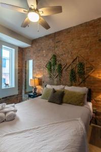 a bedroom with a large white bed with a brick wall at TRUTH Old world charm meets New world love in Cincinnati