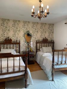 a bedroom with two beds and a chandelier at CASA DE PARDO in A Coruña