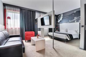 pokój hotelowy z łóżkiem i kanapą w obiekcie Hôtel des Lumières Lyon Meyzieu Arena Stadium w mieście Meyzieu