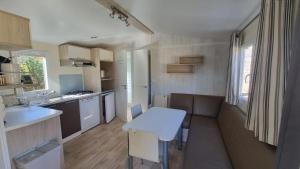 a small kitchen with a white table and a counter at gite récent, piscine privative in Boyer
