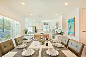 a dining room with a table and chairs and a kitchen at Sunshine Fun Time in Newport Beach