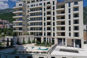 an apartment building with a balcony with a pool at CASA AL MARE RESIDENCE in Bečići
