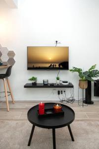a living room with a table and a tv on a wall at Studio cozy, proche paris in Le Pré-Saint-Gervais