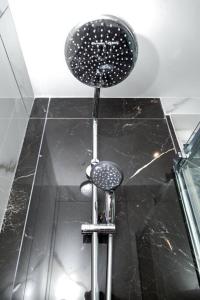 y baño con ducha y encimera negra. en Studio cozy, proche paris, en Le Pré-Saint-Gervais