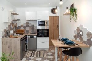 een keuken met een houten tafel en een aanrecht bij Studio cozy, proche paris in Pré Saint Gervais