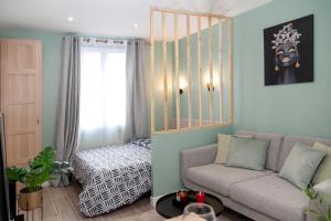 a living room with a couch and a bed at Studio cozy, proche paris in Le Pré-Saint-Gervais