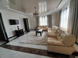 a living room with a leather couch and a table at Guest House Dimitri in Chakvi
