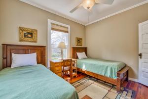 a bedroom with two beds and a desk and a window at A Beautiful View & Carriage in Lake Junaluska