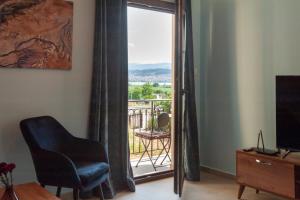 uma sala de estar com uma cadeira e uma varanda em Lago Verde em Ioannina