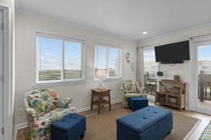 a living room with two chairs and a flat screen tv at Southwinds F6 in Atlantic Beach