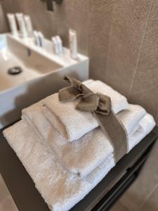 um monte de toalhas com um laço em cima de um lavatório em B&B Palazzo Bruni - Dimora di Mare em Marina di San Vito