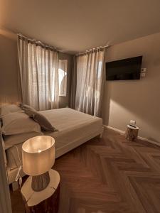 um quarto com uma cama e uma televisão de ecrã plano em B&B Palazzo Bruni - Dimora di Mare em Marina di San Vito