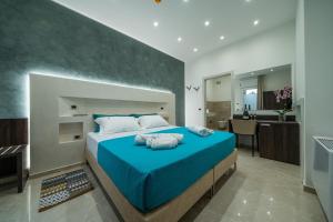 a bedroom with a blue bed and a kitchen at Casto Bed & Breakfast in Casarano