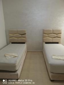 twee bedden naast elkaar in een kamer bij Appartement à louer wadie in Fnidek
