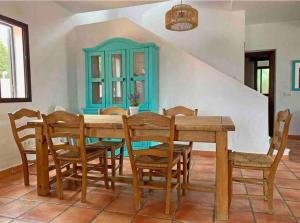 une salle à manger avec une table et des chaises en bois dans l'établissement Agradable casa de playa con piscina. El Palmar, à El Palmar